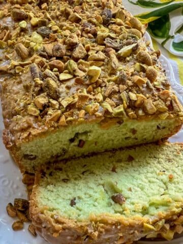 loaf of pistachio olive oil bread with one slice cut off