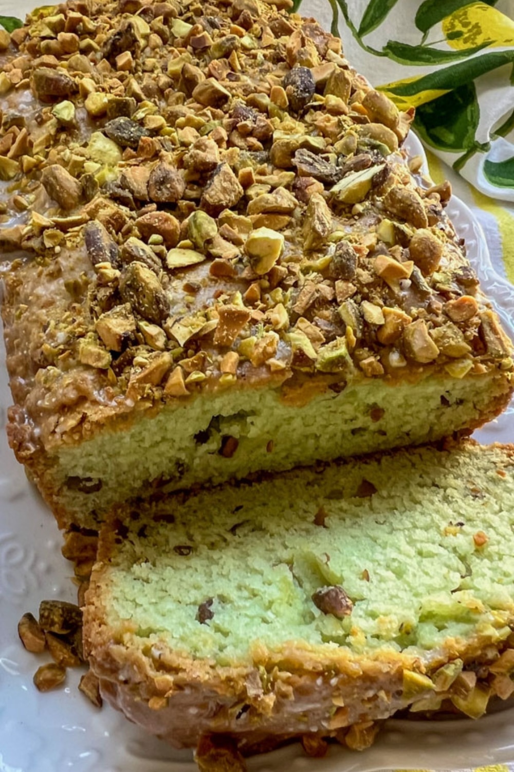 loaf of pistachio olive oil bread with one slice cut off