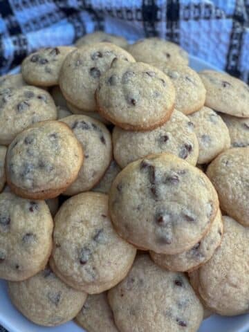 A pile of bite-sized chocolate chips cookies on a plate